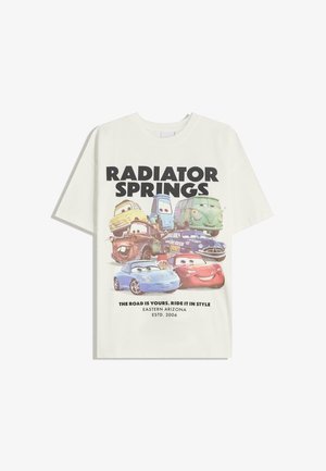 Hvid bomulds t-shirt med et grafisk design af animerede biler. Teksten lyder "RADIATOR SPRINGS" og "VEJEN ER DIN. KØR I STIL."