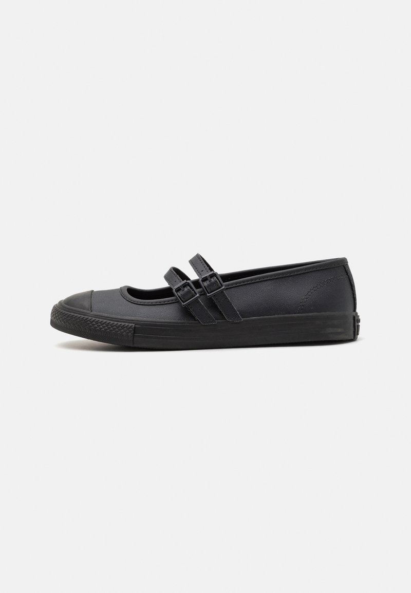 Sapatos pretos de sola plana com bico redondo, duas tiras cruzadas sobre o peito do pé, textura suave e solado de borracha com padrão texturizado.
