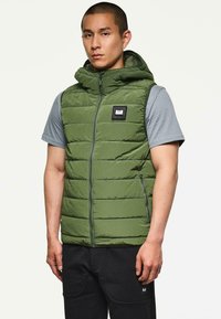 Grüne gepolsterte Weste mit Kapuze, durchgehendem Reißverschluss und seitlichen Taschen. Besitzt ein rechteckiges Logo-Patch auf der Brust und ein strukturiertes Stoffdesign.