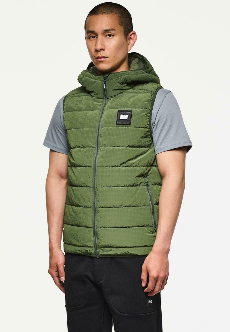 Grüne gepolsterte Weste mit Kapuze, durchgehendem Reißverschluss und seitlichen Taschen. Besitzt ein rechteckiges Logo-Patch auf der Brust und ein strukturiertes Stoffdesign.