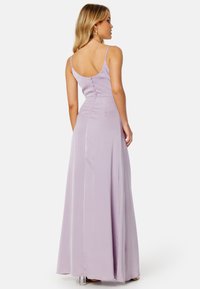 Abito serale lilla con una finitura satinata liscia, caratterizzato da una schiena bassa e dettagli con bottoni lungo la spina dorsale, che si estende fino a una gonna lunga.