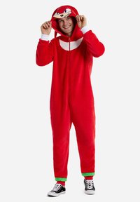Red fleece onesie with a zip-up front, white chest panel, green cuffs, and a cartoon face hood. Worn with black sneakers.