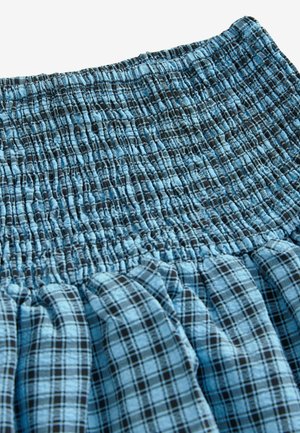 Rock mit Smockbund im hellblauen und schwarzen Karomuster. Verfügt über eine geraffte Textur und einen Rüschensaum für zusätzliche Details.