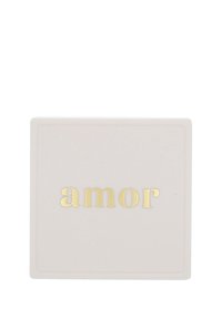 Sottobicchiere bianco quadrato con angoli arrotondati e la parola "amor" impressa in lettere dorate al centro.