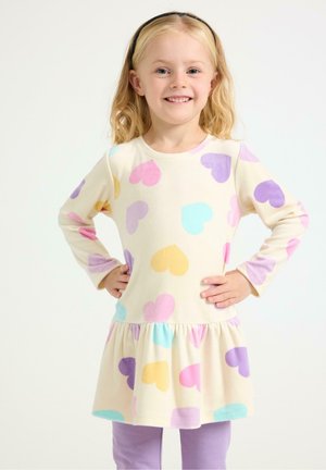 Langärmeliges Kleid mit beigem Grund, verziert mit mehrfarbigen Herzmustern in Pink, Lila und Gelb. Der Rüschensaum fügt Textur hinzu.