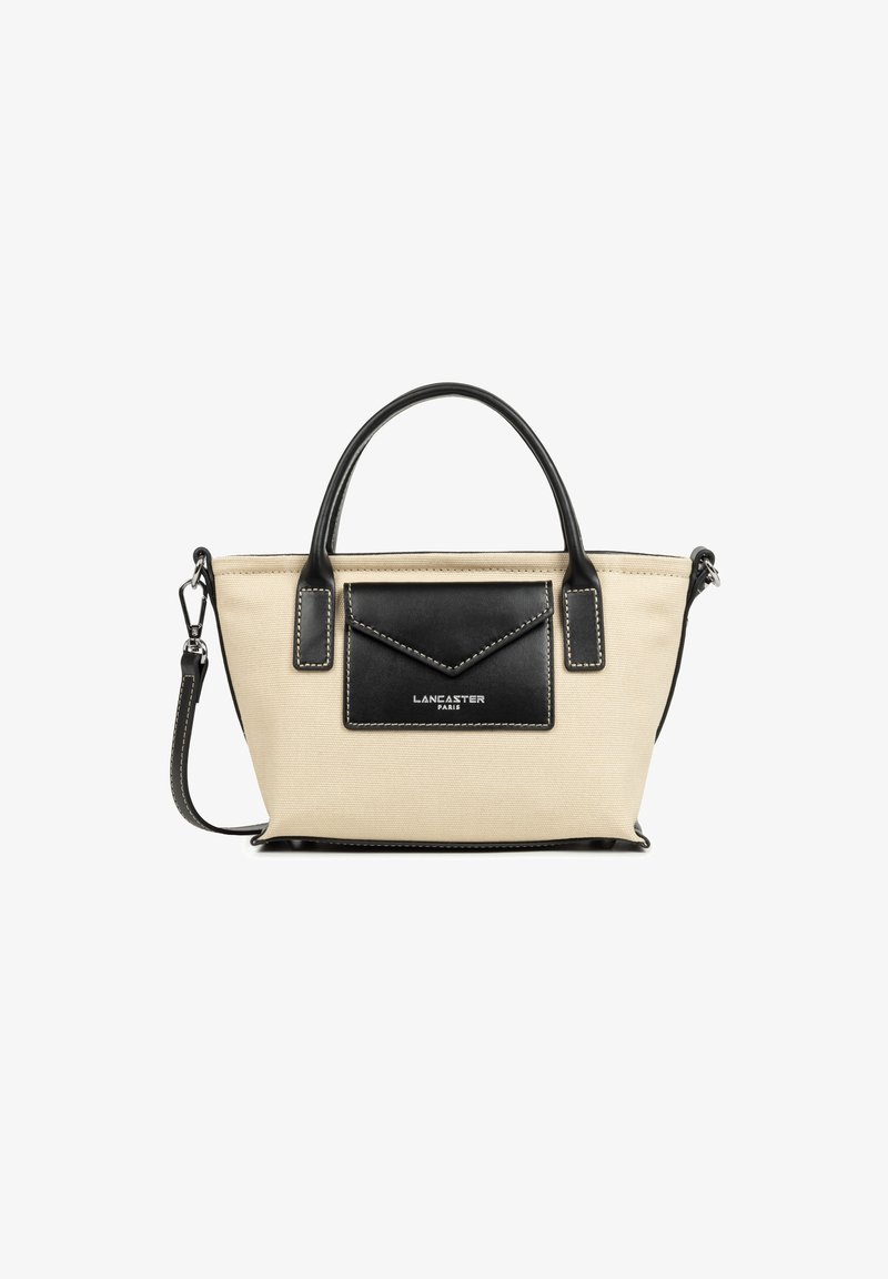 Sac fourre-tout en toile beige avec des accents en cuir noir, poignées supérieures et une poche avant. Présente des coutures contrastées et une bandoulière amovible.