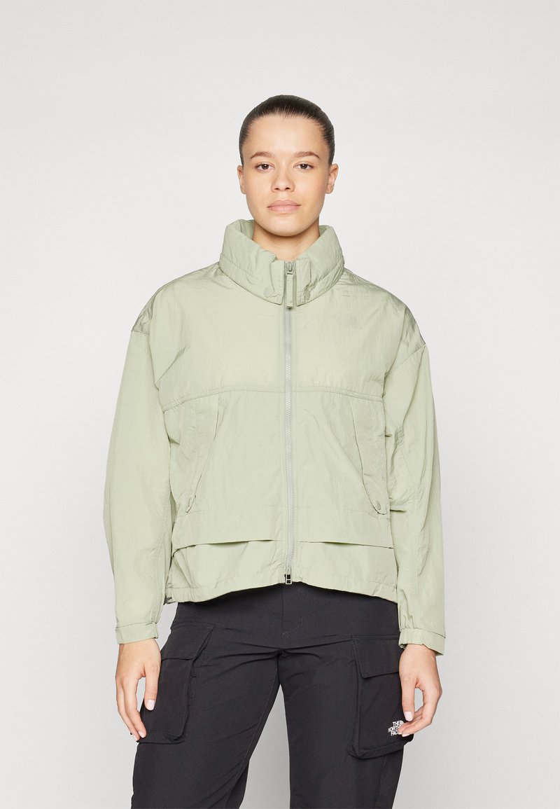 Ljusgrön zip-up jacka med hög krage, två framfickor och elastiska ärmslut. Tillverkad av ett strukturerat, lättviktsmaterial.