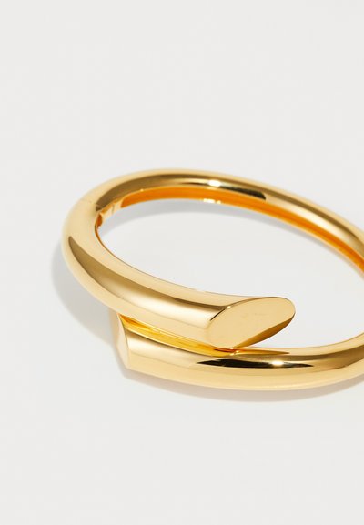 Goldfarbener Armreif mit einem eleganten, glatten Design. Verfügt über eine gebogene Form und eine markante, flache Akzentuierung an einem Ende.