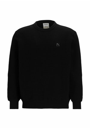Sudadera negra de canalé con cuello redondo, mangas largas y un pequeño parche con logo en el lado izquierdo del pecho. La tela parece texturizada.