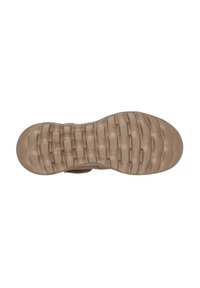 Suela de zapato con una superficie de goma texturizada y un patrón parecido a un laberinto en color beige, proporcionando agarre y flexibilidad. Sección de punta redondeada.