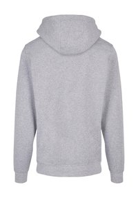 Šedá mikina s kapucí vyrobená z měkké látky, vybavená klokaní kapsou, žebrovanými manžetami a stahovací kapucí. Zadní pohled ukazuje bezšvový design.