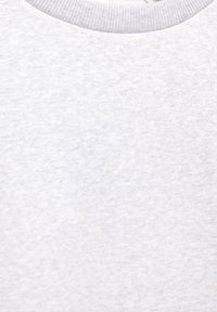 Close-up af lysegråt stof med rund hals og en subtil meleret struktur.