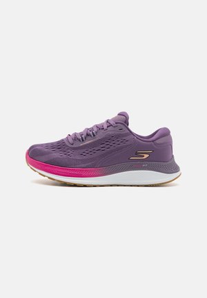 Baskets de sport violettes avec tige en maille, design effilé, accent de semelle intermédiaire rose et semelle extérieure en caoutchouc texturé. Comprend des lacets et un logo de marque.