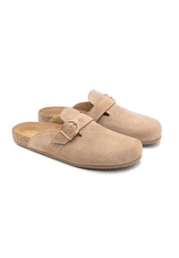 Skórzane klapki w jasnym beżu z płaską korkową podeszwą. Posiadają boczny pasek zabezpieczony metalową złotą klamrą oraz gładkie, strukturalne wykończenie.