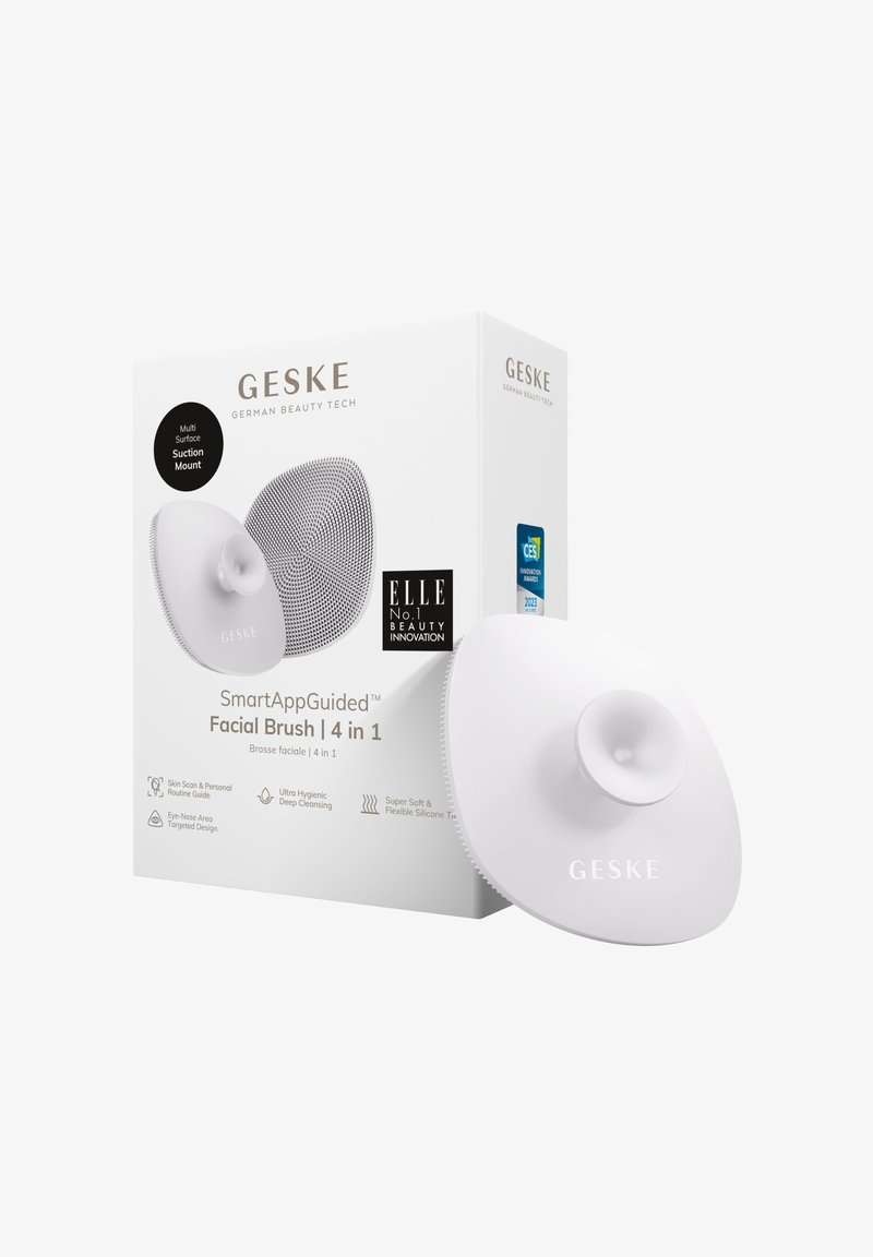 Spazzola facciale in silicone bianco con supporto a ventosa. Scatola di confezionamento con il nome del marchio "GESKE" e testo che descrive le caratteristiche e i premi.