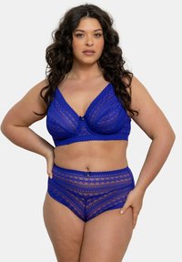 Ensemble de lingerie en dentelle de couleur bleu vif avec des motifs géométriques, un bralette à décolleté en V avec des bretelles ajustables, et un short taille haute avec des accents décoratifs.