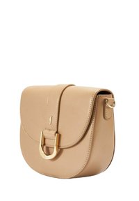 Beżowa skórzana torba na ramię z klapką, złotymi akcentami, U-kształtnym detalem i bocznym pierścieniem do mocowania paska. Gładka tekstura.