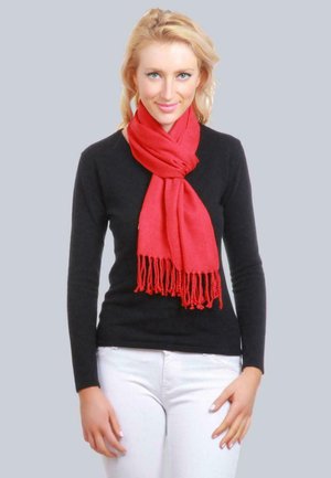 Écharpe rouge en tissu doux, avec des extrémités à franges et une texture lisse, enroulée autour du cou d'une personne portant un haut noir.