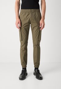 Pantalones cargo verde oliva con cintura elástica, bolsillos laterales y piernas ajustadas. Fabricados con un tejido ligero y de textura suave.