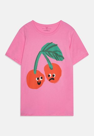 Różowy t-shirt z krótkim rękawem z dwoma czerwonymi wiśniami pokazującymi ekspresyjne twarze, jedna się uśmiecha, a druga marszczy brwi, przymocowane do zielonych łodyg i liści.