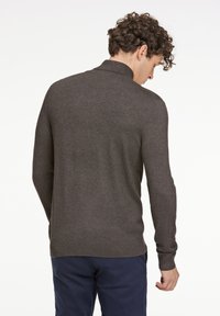 Mörkgrå stickad oversized tröja med ribbat krage och manschetter, som har en smal passform och en mjuk textur. Utsikt bakifrån.