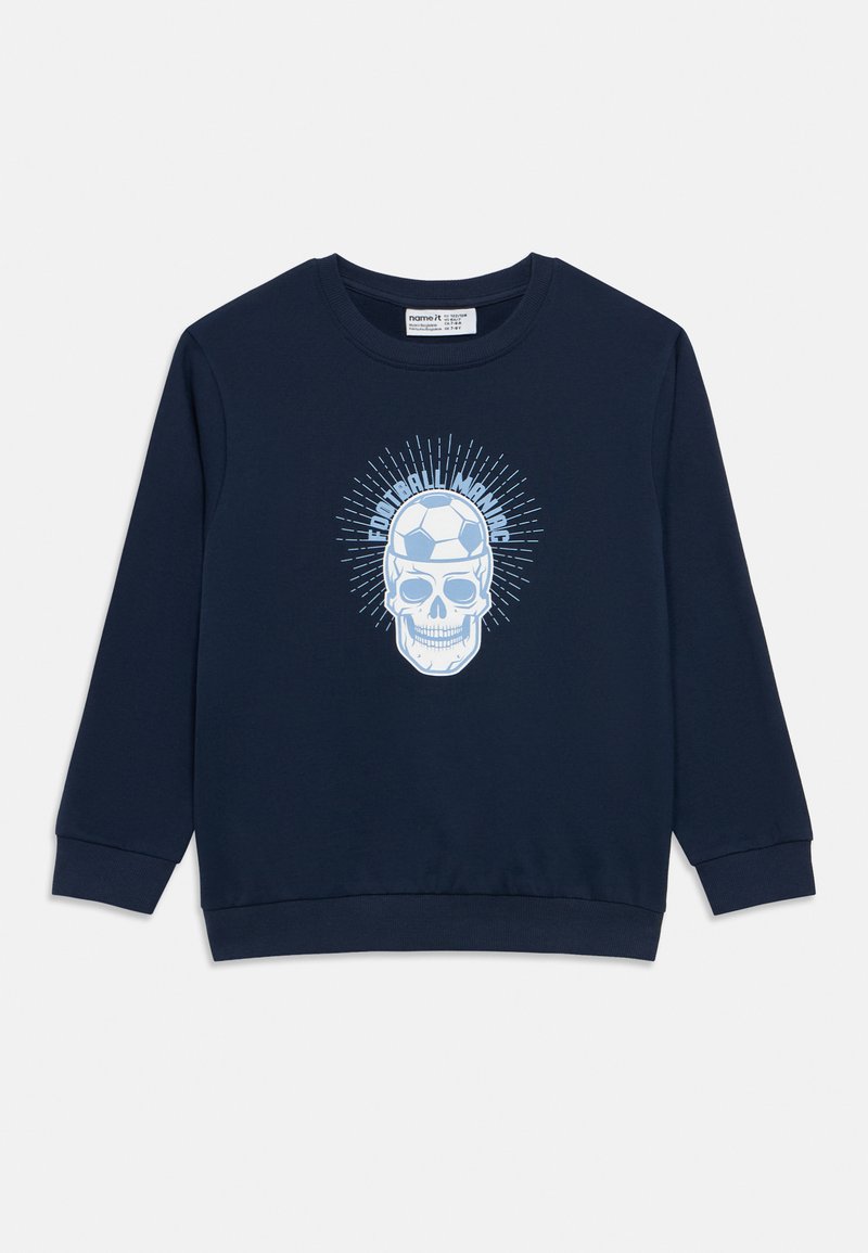 Σκούρα μπλε φούτερ από βαμβάκι, με λευκό γραφικό κρανίο που φορά ένα ποδοσφαιρικό κράνος, περιβαλλόμενο από ακτινωτές γραμμές. Μακριά μανίκια, ριμπ μανσέτες.