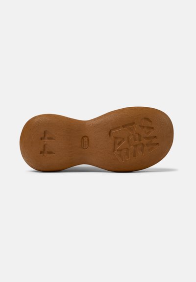 Semelle de chaussure en caoutchouc marron avec une finition texturée, présentant une forme ondulée et un motif moulé, incluant le numéro "44" et des lettres abstraites.