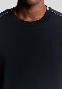 Felpa nera a collo rotondo caratterizzata da una texture a costine, design slim fit e sottili accenti grigi sulle cuciture delle spalle.