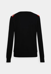 Czarny sweter z długimi rękawami, okrągłym dekoltem oraz kontrastującymi czerwonym, beżowym i niebieskim akcentem na ramionach. Gładka tekstura, dopasowany fason.