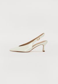 Chaussure slingback en cuir verni blanc avec un bout pointu et un talon fin. Présente une sangle étroite ajustable avec un détail de boucle carrée.