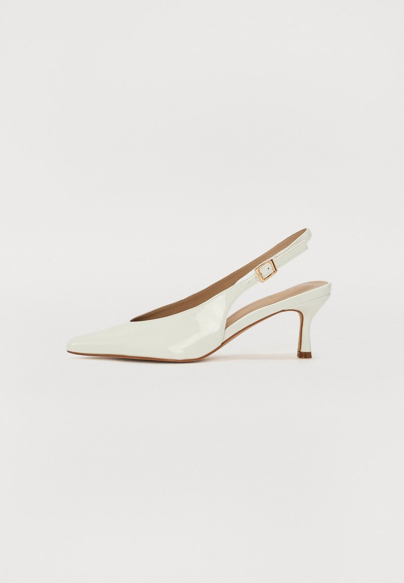 Chaussure slingback en cuir verni blanc avec un bout pointu et un talon fin. Présente une sangle étroite ajustable avec un détail de boucle carrée.