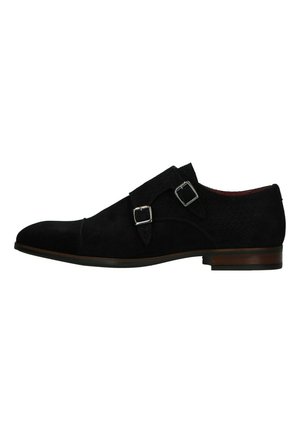 Soulier habillé en suède noir avec une silhouette épurée, doté de deux sangles à boucles en argent, d'un bout incurvé et d'une tige texturée.