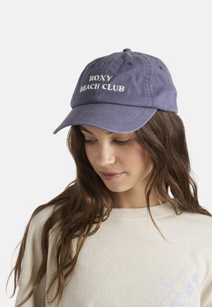 Donkerblauwe katoenen pet met "ROXY BEACH CLUB" in witte letters geborduurd op de voorkant. Gebogen klep en verstelbare band aan de achterkant.