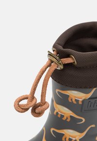 Botte en caoutchouc avec un corps gris foncé, motifs de dinosaures orange, manchette en mesh marron et lacet marron avec un verrou métallique réglable.