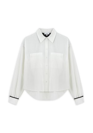 Blusa blanca corta en tela ligera. Presenta un cuello clásico, cierre de botones, dos bolsillos en el pecho y detalles en negro en los puños.