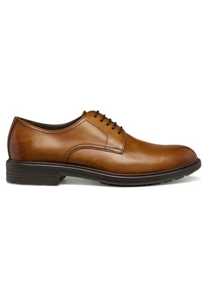 Zapato de vestir para hombre de cuero marrón con suela de goma negra y cordones negros, vista lateral sobre fondo blanco.