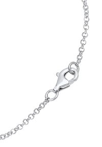 Silverfärgad kedjebrastet med en krabba-lås. Har små, sammanlänkade länkar och en polerad yta. Märkt med "925" för silverrenhet.