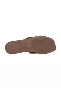 Semelle de chaussure marron présentant une texture lisse et un motif nervuré pour une meilleure adhérence. Forme arrondie avec un talon plat et un minimum de détails.