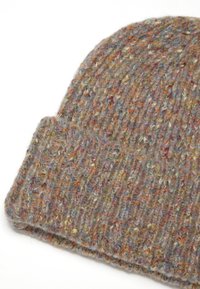 Gorro de lana tejido en color beige con manchas multicolores. Presenta una textura acanalada y un puño doblado. Apariencia suave y acogedora.