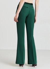 Pantaloni verde, a vita alta, svasati, con texture liscia e design elegante. Include due tasche posteriori con sottili dettagli in satin.