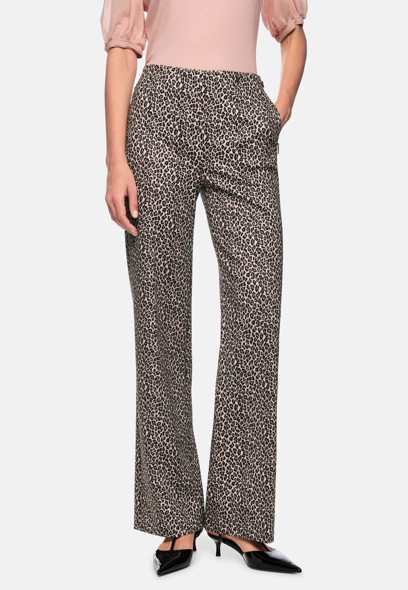 Leopard print trousers with a straight leg design, featuring side pockets and a smooth fabric. Worn with black pointed shoes.