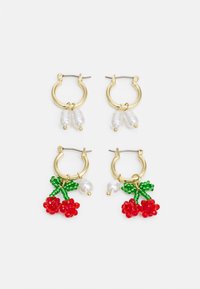 Brincos de argola dourados com dois designs: um com acentos de pérolas brancas e outro adornado com cerejas de contas vermelhas e folhas verdes.