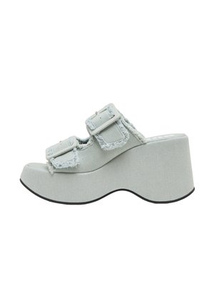 Jasnoniebieskie klapki na platformie z postrzępionymi krawędziami, podwójnymi regulowanymi paskami i grubym koturnem. Gładka faktura tkaniny i okrągły kształt noska.