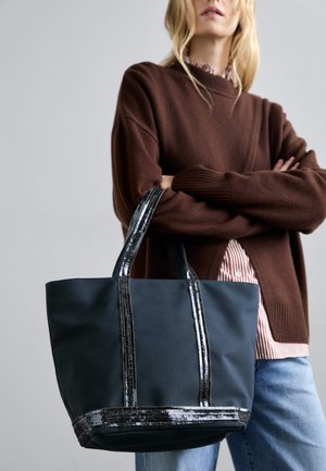 Grote zwarte tote bag met twee handvatten versierd met pailletten, gemaakt van stevige stof. Heeft een eenvoudig rechthoekig ontwerp en een gladde textuur.