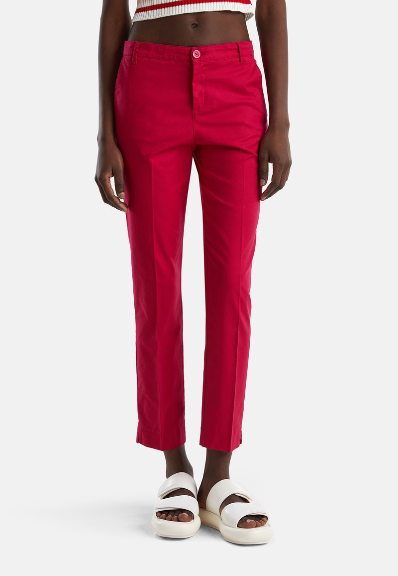 Röda bomullsbukser med slim fit, framfickor, bälteshällor och knappstängning. Matchas med vita platåsandaler.