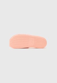 Pink rubber shoe sole with a textured grip pattern, featuring a rounded toe and an overall smooth finish.