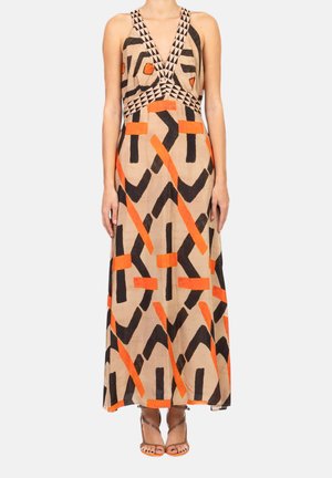 Abito lungo con base beige, motivi geometrici astratti neri e arancioni, scollo a V profondo con bordatura triangolare, indossato con tacchi con cinturini.