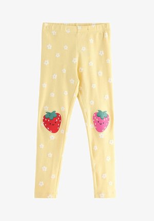 Gule børneleggings med hvid blomsterprint og smilende røde og pink jordbær-patches på knæene.