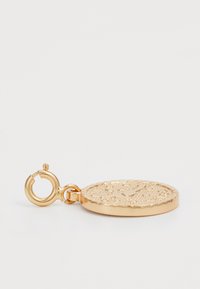 Gullpendant med en teksturert sirkulær overflate og en bølget kant, med en krok for feste.