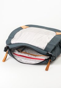 Blue and grey textured bag with a zip closure, featuring a lined interior, leather accents, and an internal red zip pocket.